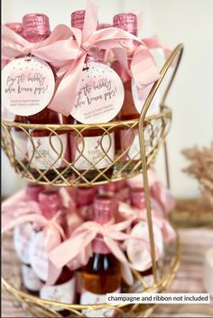 there is a basket filled with bottles of honey on top of a table and pink bows