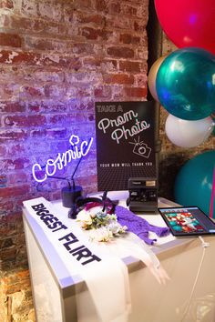 a table with balloons and signs on it