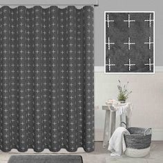 a black and white shower curtain in a bathroom with a rug on the floor next to it