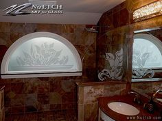 a bathroom with two sinks and an arched window in the wall next to each other