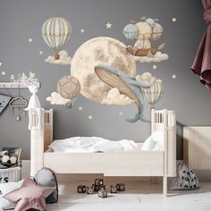 a child's bedroom decorated in gray and white with hot air balloons flying over the bed