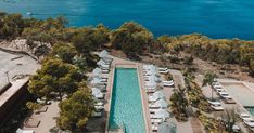 an aerial view of the pool and surrounding resort buildings, with boats in the water