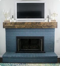 a fireplace with a flat screen tv mounted above it and candles on the mantel