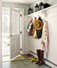 a hat and boots are hanging on the wall next to a coat rack with hats