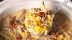 a spoon full of soup with chicken and corn