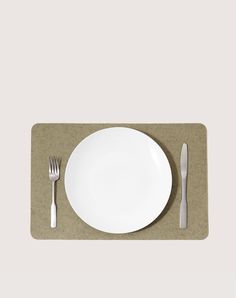 a place mat with a white plate and silverware on it