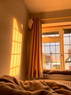 the sun is shining through two windows in a room with a bed and window sill