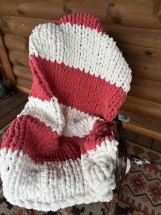 a red and white blanket sitting on top of a chair