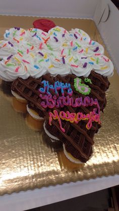 a birthday cupcake with white frosting and sprinkles on the top