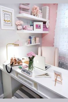 a white desk topped with a laptop computer next to a pink flower filled vase on top of it