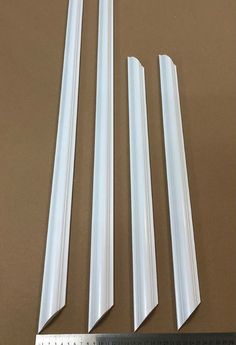 four different sizes of white plastic tubes on a table