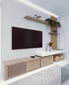 a flat screen tv mounted to the side of a wall in a white living room