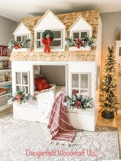 a doll house with christmas decorations on the roof and window boxes in the top floor