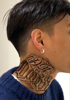 a woman with black hair wearing a large wooden earring that has an intricate design on it