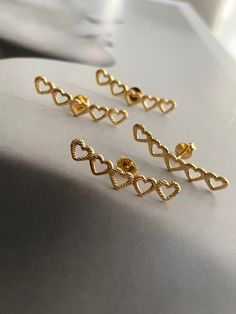 Boldly wear your heart on your ears with our Lined Hearts Earrings! Made with gold plated post back studs, these heart-shaped earrings will add a touch of daring to any outfit. Perfect for the risk-taker in you! Dainty Heart-shaped Earrings For Parties, Heart-shaped Plug Earrings For Valentine's Day, Dainty Heart Earrings For Party, Gold Open Heart Earrings For Party, Gold Heart Earrings With Heart Detail, Gold Heart Plug Earrings, Gold Heart Shaped Plug Earrings As Gift, Gold Heart-shaped Plug Earrings As Gift, Heart-shaped Gold Plug Earrings As Gift