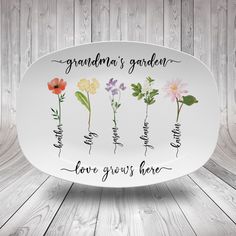 a white plate with flowers on it that says grandma's garden love grows here