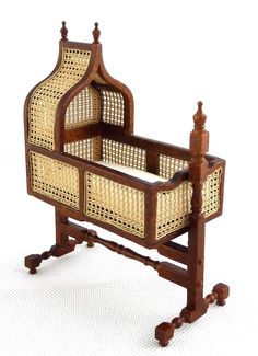 an antique wooden cradle with wicker baskets on it's sides and legs, against a white background