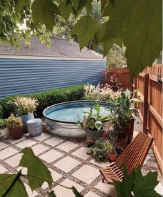 an outdoor hot tub surrounded by potted plants