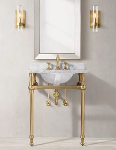 a white sink sitting under a mirror next to a wall mounted faucet in a bathroom