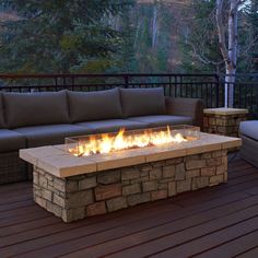 a fire pit sitting on top of a wooden deck next to a couch and table