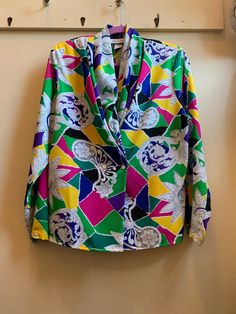 "This blouse is for someone who like to have fun with their wardrobe. Isn't afraid to add more than a few splashes of colour and a cool retro vibe. It's a deep V blouse with hidden buttons. Would look awesome tucked into high waisted pants or pencil skirt but also try it over leggings and ankle boots. Size on tag says 14 please see measurements. In very good preowned condition and Made in the USA.  \"pit to pit\" measurement 20.5\" Shoulders 17\" (has shoulder pads that you could remove) Length 23\" V3" Fun Multicolor Long Sleeve Shirt, Fun Multicolor V-neck Tops, Retro Multicolor Tops With Abstract Print, Fun Long Sleeve Printed Tops, Retro Multicolor Abstract Print Tops, Multicolor Retro Print Long Sleeve Blouse, Multicolor Retro Print Long Sleeve Top, Multicolor Long Sleeve Retro Print Blouse, Long Sleeve Multicolor Retro Print Blouse