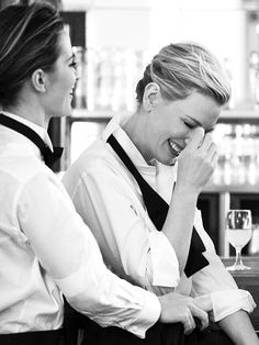 two women sitting at a bar laughing