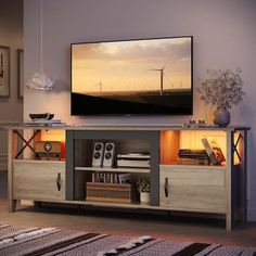 a flat screen tv sitting on top of a wooden entertainment center in a living room