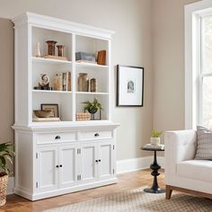 a living room filled with furniture and a white bookcase on top of a hard wood floor