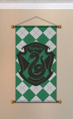 a green and white wall hanging with a sly crest on it's side in front of a beige wall