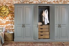 an image of a bedroom setting with grey cupboards and clothes hanging on the wall