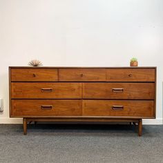 a large wooden dresser sitting on top of a carpeted floor next to a wall