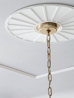 a chandelier hanging from the ceiling in a room with white walls and ceilings