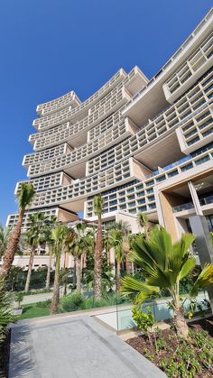 an apartment building with many balconies and palm trees