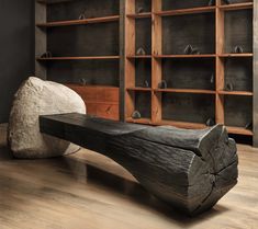 a wooden bench sitting on top of a hard wood floor next to bookshelves