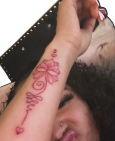 a close up of a person with a tattoo on her arm and the word love written in cursive writing