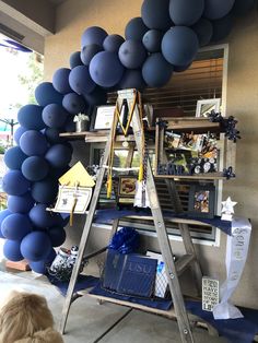 a ladder with blue balloons hanging from it