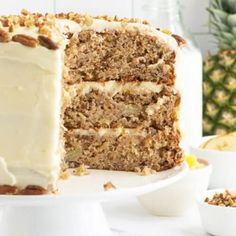 a cake with white frosting and walnuts on the top is cut into pieces