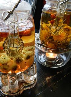 two glass jars filled with tea and flowers