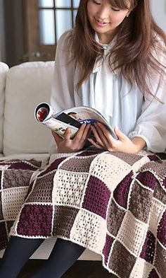 a woman sitting on a couch reading a book