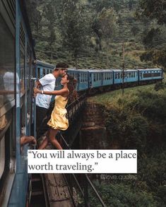 a man and woman kissing on the side of a train as it goes over a bridge