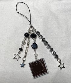 a black and white photo hanging from a silver chain with charms attached to it's sides