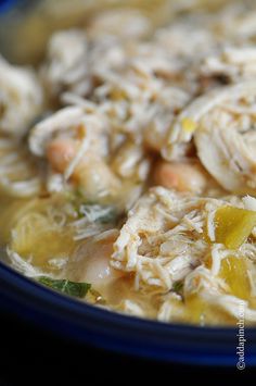 a blue bowl filled with chicken and vegetable soup