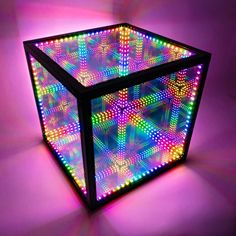 a lit up cube sitting on top of a purple floor in front of a pink background