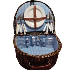 a wicker picnic basket with utensils, plates and napkins in it