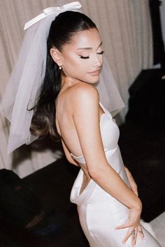 a woman in a white dress with a veil on her head