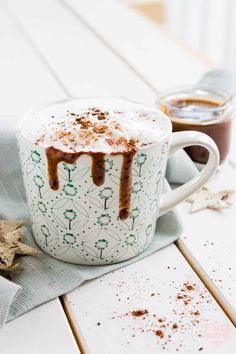 two cups filled with hot chocolate on top of a table