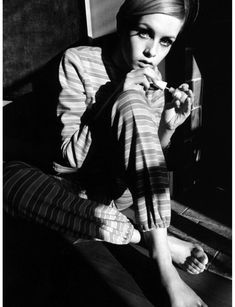 black and white photograph of a woman sitting on the floor with her hand in her mouth