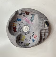 a coin sitting on top of a metal object with graffiti all over it