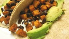 two tortillas with black beans, avocado and sour cream on them