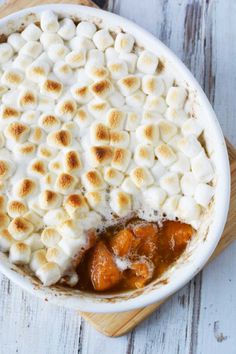 a pie with marshmallows in it sitting on top of a wooden cutting board